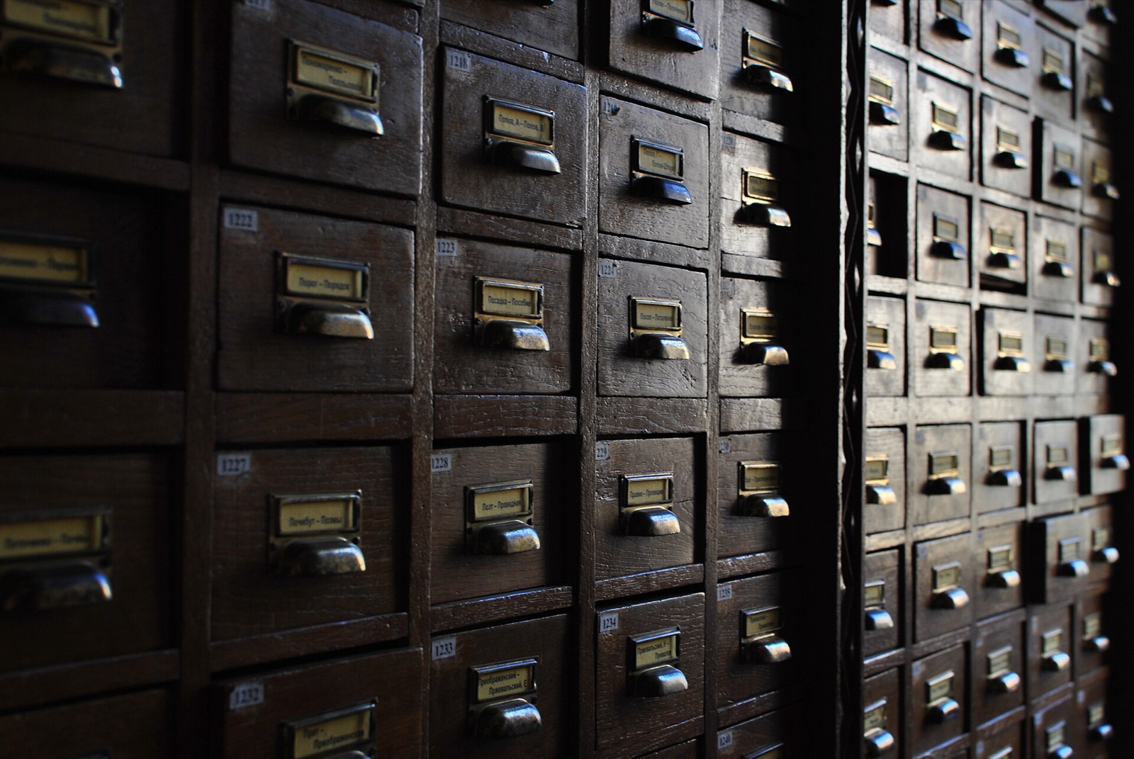 Rows of wooden card catalogue drawers with brass label holders